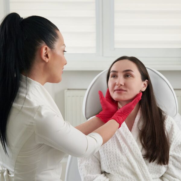 Skincare specialist assessing patient's skin