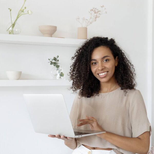 woman smiling, holding laptop