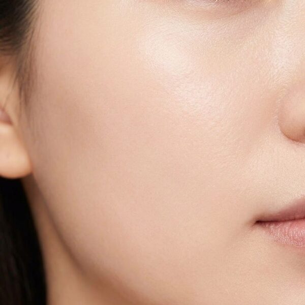 A macro photograph focusing on the refined, smooth skin texture on a person's cheek.